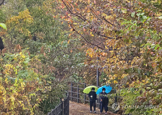전국 곳곳에 가을비가 내린 지난 1일 오전 강원 춘천시 삼천동의 산책로에서 우산을 쓴 시민들이 걷고 있다. 연합뉴스